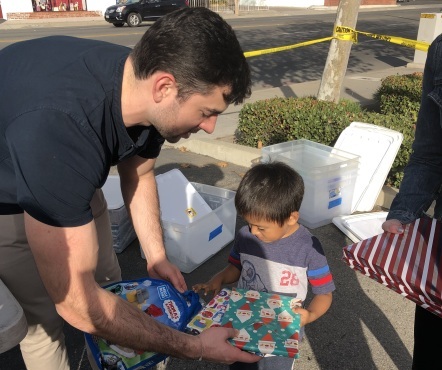 Michael Camarda distributing gift-wrapped books