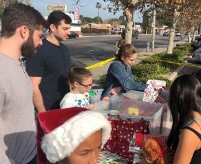 Nick and Michael Camarda distributing donated gift-wrapped books in 2017