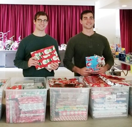 Michael and Nick Camarda distributing gift-wrapped books